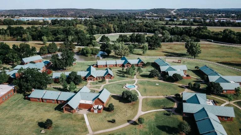 Aerial view of a scenic countryside estate with multiple buildings and lush greenery.