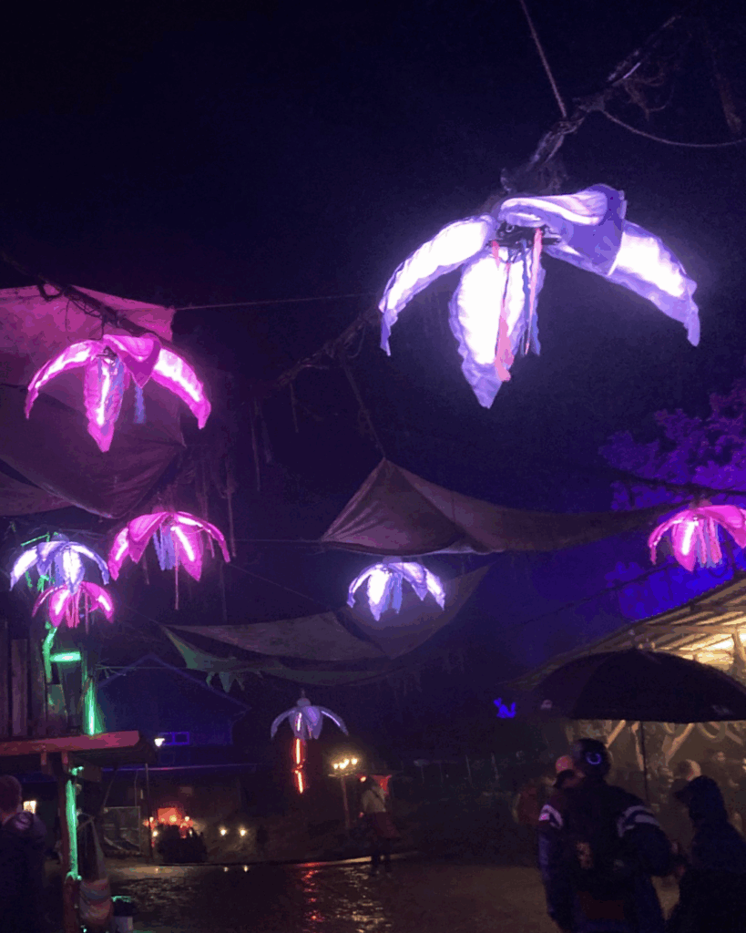 Colorful illuminated hanging decorations at a nighttime festival create a magical atmosphere.