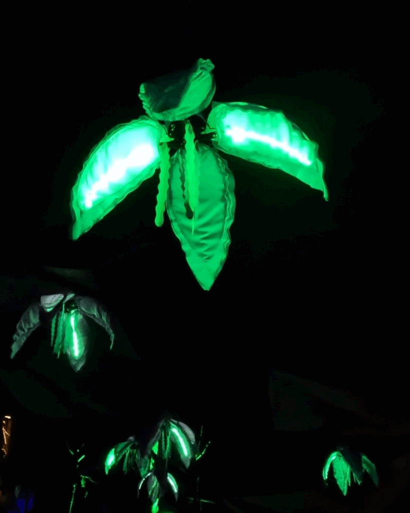 Glowing green LED leaves in the dark, creating a vibrant, futuristic botanical scene. Ideal for garden lighting concepts.