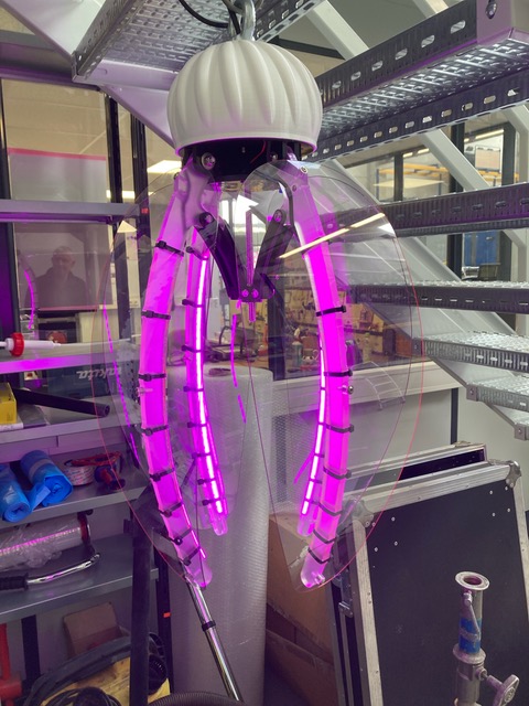 Futuristic robotic claw with purple lights in a laboratory setting, showcasing advanced technology and innovation.